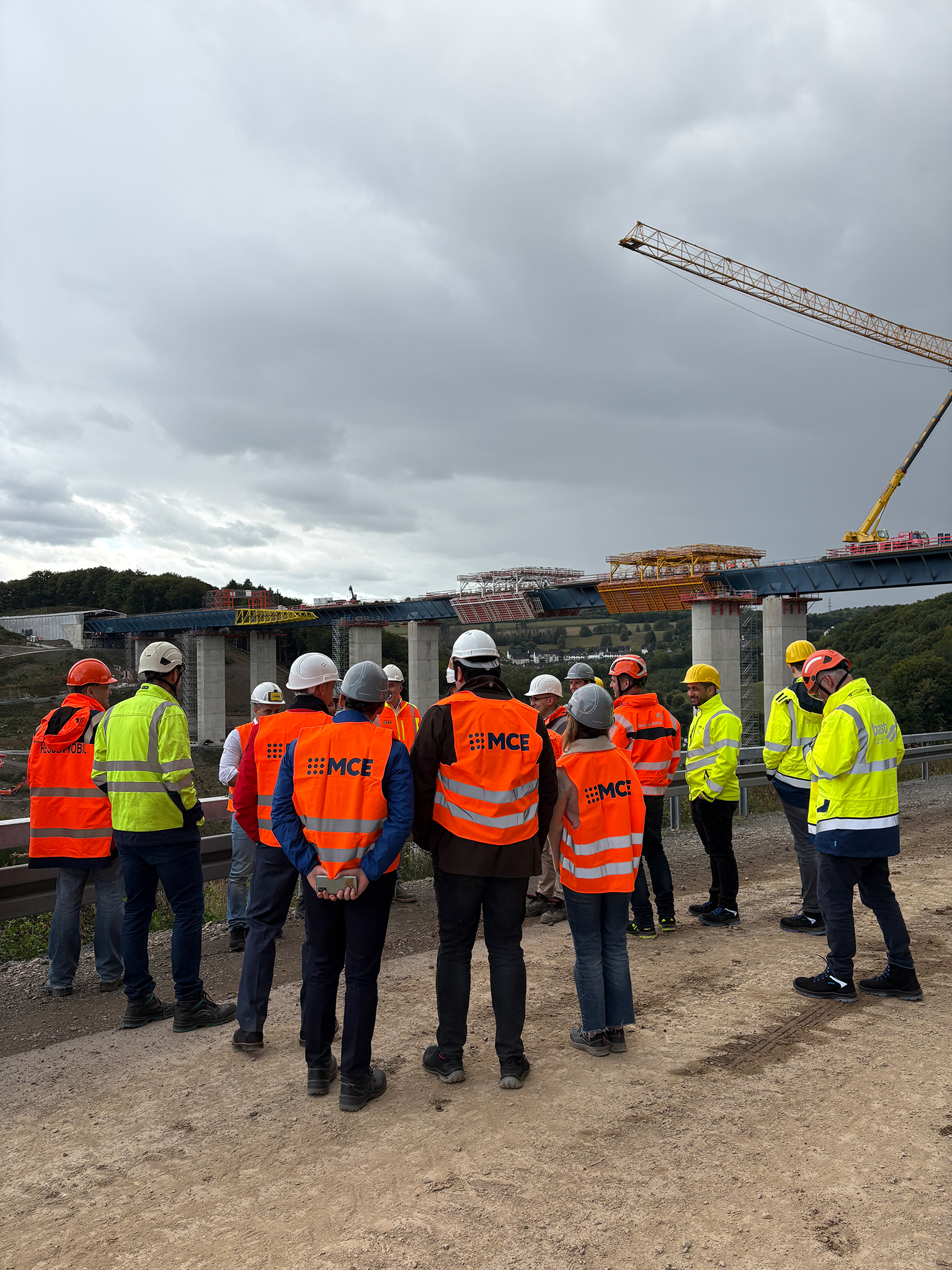 Teilnehmer des Fachtags-Brückenbau stehen vor der im Bau befindlichen Talbrücke Rahmede